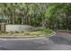 Community entrance sign featuring mature trees, lush landscaping, and upscale design elements at 8059 Shadow Oak Dr, North Charleston, SC 29406