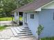 Image of a homes rear exterior showing a patio and steps up to a door under a partially cloudy sky at 93 Knights Ave, Walterboro, SC 29488