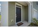 Close-up of the front door with a welcoming mat, stylish exterior, and tidy landscaping at 1032 Peridote Way, Ladson, SC 29456
