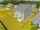 Aerial view of the home's rear exterior showcasing the siding, small patio, and expansive, partially grassy backyard at 1032 Peridote Way, Ladson, SC 29456