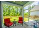 Relaxing screened patio with red cushioned chairs, small table, and wooded views at 104 Limpkin Ln, Summerville, SC 29483