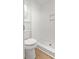 Clean bathroom with a white toilet, white textured walls, and white tiled shower at 107 Sugarpine Pl, Summerville, SC 29486