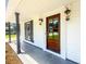 Inviting front porch showcasing a wood front door with decorative lanterns at 107 Sugarpine Pl, Summerville, SC 29486