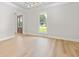 Bright living room featuring wood-look floors, elegant trim, and a view to the front yard at 107 Sugarpine Pl, Summerville, SC 29486