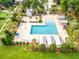 Aerial view of a community pool area with cabanas, palm trees, lounge chairs, and manicured landscaping at 109 Goose Rd, Summerville, SC 29483