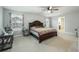 Spacious bedroom featuring neutral carpet, a ceiling fan, and a large bed with patterned bedding at 109 Goose Rd, Summerville, SC 29483