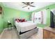 Well-lit bedroom with green walls, a ceiling fan, and a comfortable bed with decorative pillows at 109 Goose Rd, Summerville, SC 29483
