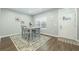 Well-lit dining area with a wood table, four chairs, and a decorative rug adjacent to the entryway at 109 Goose Rd, Summerville, SC 29483