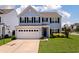 Charming blue two-story home with a well-manicured lawn and a two-car garage on a sunny day at 109 Goose Rd, Summerville, SC 29483