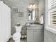 Modern bathroom with a gray vanity, decorative wallpaper, and a framed mirror at 1100 Griswold St, Mount Pleasant, SC 29466