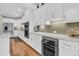 Modern kitchen featuring white cabinetry, stainless steel appliances, a wine cooler, and light grey backsplash at 1100 Griswold St, Mount Pleasant, SC 29466