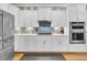 Modern kitchen with stainless steel appliances, gas cooktop, grey backsplash, and ample white cabinets at 1100 Griswold St, Mount Pleasant, SC 29466