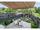 Cozy backyard patio with fire pit, adirondack chairs, awning and manicured landscaping at 1100 Griswold St, Mount Pleasant, SC 29466