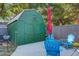 Backyard with a green shed, an umbrella for shade, and inviting blue chairs, perfect for outdoor relaxing at 1126 Brigantine Dr, Charleston, SC 29412