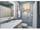 Bathroom with marble vanity top, classic fixtures, decorative mirror, and a window offering natural light at 1126 Brigantine Dr, Charleston, SC 29412
