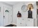 Bright entryway with white door, decor, and a charming sideboard with decorative birdhouses and clock at 1126 Brigantine Dr, Charleston, SC 29412