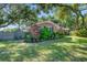 Well-kept brick home surrounded by mature trees, lush landscaping, and a manicured lawn at 1126 Brigantine Dr, Charleston, SC 29412