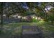 Brick home exterior with lush greenery and a wooden bench under the trees at 1126 Brigantine Dr, Charleston, SC 29412