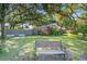 Brick home nestled in a lush landscape with mature trees and a quaint wooden bench at 1126 Brigantine Dr, Charleston, SC 29412