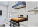Modern kitchen features white cabinets, marble countertops, and a stainless steel stove with a blue vent hood at 1126 Brigantine Dr, Charleston, SC 29412