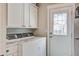 Functional laundry room with white cabinets, side by side washer and dryer, and access to the outdoors at 1126 Brigantine Dr, Charleston, SC 29412