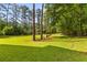 Expansive backyard lawn surrounded by mature trees, providing a private and peaceful setting at 129 Martins Point Dr, Wando, SC 29492