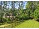 A backyard features a lush green lawn, tall trees, and a black metal fence enhancing the outdoor space at 129 Martins Point Dr, Wando, SC 29492
