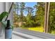 Window view of a lush green backyard with tall trees and a glimpse of a fence at 129 Martins Point Dr, Wando, SC 29492