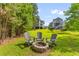 Backyard fire pit with Adirondack chairs creating a cozy and inviting outdoor space at 129 Martins Point Dr, Wando, SC 29492