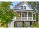 Charming two-story home featuring a welcoming front porch, two-car garage, and lush landscaping at 129 Martins Point Dr, Wando, SC 29492