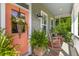Inviting front porch with rocking chairs, decorative plants, and a charming peach-colored front door at 129 Martins Point Dr, Wando, SC 29492