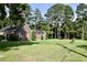Brick home with side garage, green lawn, landscaping and mature trees, showcasing a peaceful and inviting property at 1457 Green Pond Hwy, Walterboro, SC 29488
