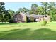 Picturesque brick home with a sprawling green lawn, complemented by mature trees for a tranquil and inviting exterior at 1457 Green Pond Hwy, Walterboro, SC 29488