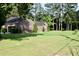 Side view of a brick home with green lawn and partial garage view, surrounded by mature trees on a sunny day at 1457 Green Pond Hwy, Walterboro, SC 29488