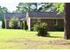 Brick home with landscaping, including evergreen trees and lawn. Tall mature trees in background. Long ranch style design at 1457 Green Pond Hwy, Walterboro, SC 29488
