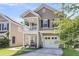 Attractive two-story home with a front porch, garage, and neat landscaping, enhancing its welcoming appearance at 153 Instructor Ct, Ladson, SC 29456