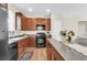Functional kitchen featuring wood cabinets, black appliances, and a view of the living room at 153 Instructor Ct, Ladson, SC 29456