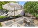 Charming backyard with a gravel patio, outdoor furniture, and a white umbrella at 176 Smith St, Charleston, SC 29403