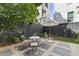 Inviting backyard featuring a stone patio, white metal furniture and a charming white umbrella at 176 Smith St, Charleston, SC 29403