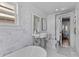 Charming bathroom with marble tile, pedestal sink, and an open view to the bedroom at 176 Smith St, Charleston, SC 29403