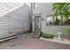 Exterior shot of a home with gray wood siding, a brick patio and stone steps leading to the door at 176 Smith St, Charleston, SC 29403