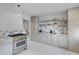 Modern kitchen with stainless steel range, custom cabinets, marble counters and backsplash, and white painted floors at 176 Smith St, Charleston, SC 29403