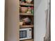 Organized pantry shelving with microwave, bowls, and packaged goods at 176 Smith St, Charleston, SC 29403