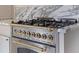 Close up of a stainless steel stove with brass knobs and a marble countertop at 176 Smith St, Charleston, SC 29403