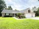 Charming brick home featuring a manicured lawn, three-car garage, and lush landscaping at 1804 Bass Rd, Moncks Corner, SC 29461