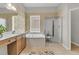 Bathroom featuring double sinks, soaking tub, glass shower and neutral tile at 1809 Two Cedar Way, Mount Pleasant, SC 29466