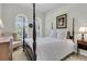 Primary bedroom features a four poster bed, neutral walls, and arched windows with views at 1809 Two Cedar Way, Mount Pleasant, SC 29466