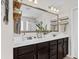 Bathroom featuring dual sinks, dark cabinets, granite counters, and lots of storage at 1821 Towne St, Johns Island, SC 29455