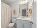 Bright bathroom featuring a seashell themed shower curtain, white vanity, and a large mirror at 202 Kirkland St, Goose Creek, SC 29445