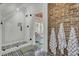Stylish bathroom boasts a glass walk-in shower, exposed brick wall, and patterned black and white flooring at 208 Sumter Ave, Summerville, SC 29483